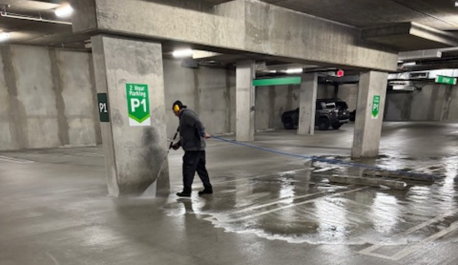 Professional washing the floor of a parking garage